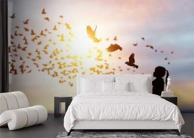 silhouette of bird flying out of Girl child hand on beautiful background.freedom concept ,International Working Women's Day Wall mural