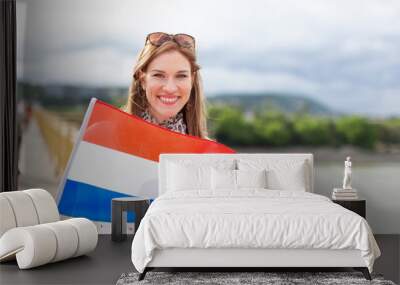 Happy young woman holding Dutch flag Wall mural