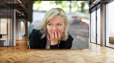 Middle aged blonde woman in park looking away Wall mural