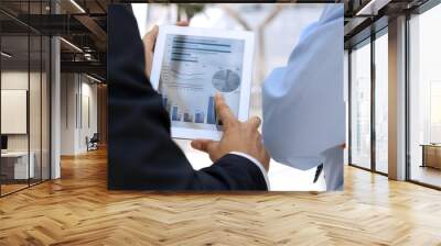 Business colleagues working and analyzing financial figures  Wall mural