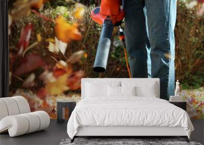 Man working with  leaf blower: the leaves are being swirled up a Wall mural