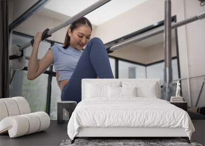 Asian Woman on Reformer at Pilates gym Wall mural