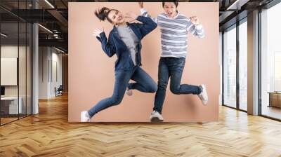 cheerful positive Asian couple  jumping in the air Wall mural