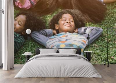 happy children kids laying on grass in park Wall mural