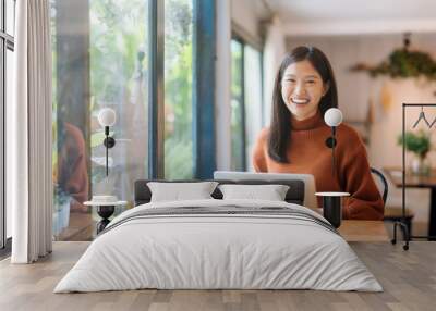 happy young asian girl working at a coffee shop with a laptop Wall mural