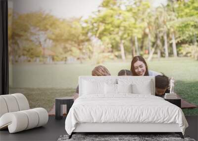 Modern family using laptop while resting in park Wall mural