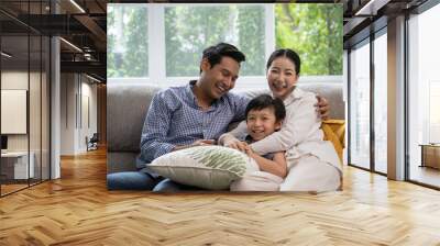 portrait of happy Asian family spending time together on sofa in living room. family and home concept. Wall mural