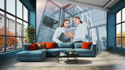 Business lady. Office staff. Two young girls with electronic tab Wall mural