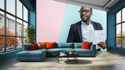 African man in glasses presents architectural plans with a smile in a stylishly decorated workspace Wall mural