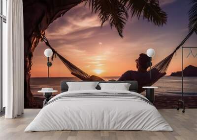 man relaxing in a hammock on the beach at sunset Wall mural