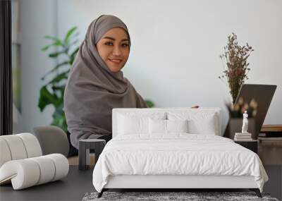 Millennials Arabian businesswoman in hijab working with tablet and laptop at her office desk. Wall mural