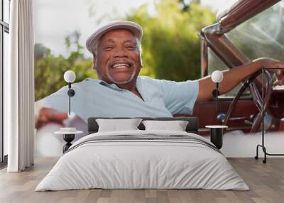 Smiling older man driving convertible Wall mural