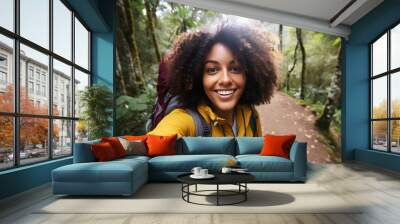 Happy traveller black woman with backpack taking selfie picture in forest- Travel blogger taking self portrait with smart mobile phone device outside - Life style and technology concept Wall mural