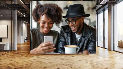 woman and man  sitting at a table, smiling while watching their phone together Wall mural