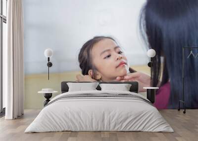 Closeup shot of a cute Southeast Asian baby girl staring at her mom Wall mural