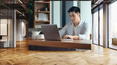 Young asian man student using laptop computer at home studying online panoramic banner. Creative professional working in office. Distance study, work from home, e-learning, business, meeting online Wall mural