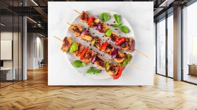 Chicken breast fillet grilled barbecue skewers with vegetables and basil in a plate on white table. top view Wall mural