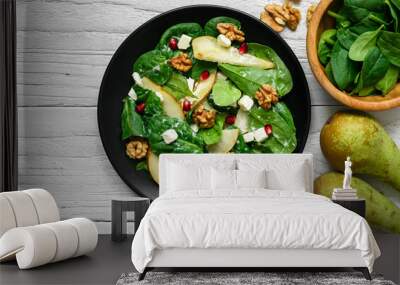 fresh spring salad with spinach leaves, pear, nuts, pomegranate and feta cheese in black plate Wall mural