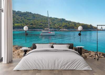 Turquoise water bay of Adriatic sea on Hvar island with yacht in Dalmatia region, Croatia in sunny day Wall mural