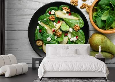 vitamin salad with spinach leaves, pear, nuts, pomegranate and feta cheese in black plate Wall mural