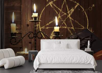 Magic candles and books on background with pentagram Wall mural