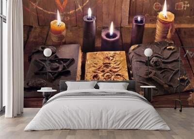 Mystic Halloween still life. Three magic books with burning candles on planks.  Wall mural