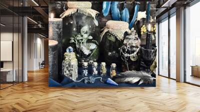 Styled still life with magic bottles with potions and herbs, runes, black candles and skull on witch table. Esoteric, gothic and occult background, Halloween mystic concept. Wall mural