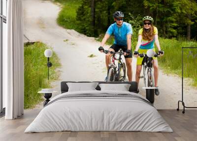 ACTIVE Young couple biking on a forest road in mountain on a spring day Wall mural