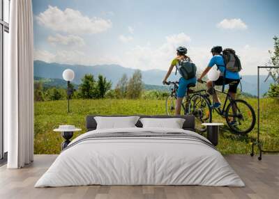 ACTIVE Young couple biking on a forest road in mountain on a spring day Wall mural