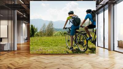 ACTIVE Young couple biking on a forest road in mountain on a spring day Wall mural