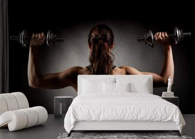 Atractive fit woman works out with dumbbells as a fitness concep Wall mural