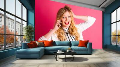 excited blonde teenage girl talking on smart phone over pink bac Wall mural