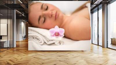 Woman lying on massage table prepaired for beauty treatment. Wall mural