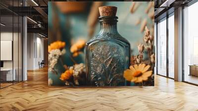 A close-up of a vintage glass bottle with intricate embossing, surrounded by dried flowers, creating a nostalgic and rustic aesthetic. Wall mural