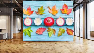 A festive table setting featuring pomegranate halves as decorative elements, along with candles and autumn leaves, creating a warm, inviting atmosphere. --chaos 70 Wall mural