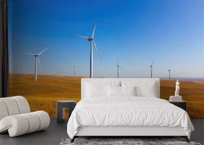 A group of wind turbines standing tall on the plains, their blades slowly turning in the breeze under a clear, cloudless sky. Wall mural