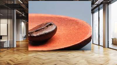 Roasted coffee bean on wooden spoon close up. Wall mural