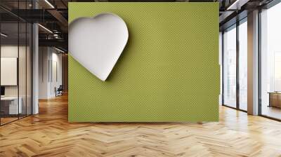 An empty, white heart-shaped box on a yellow-green background with a white flower pattern.  Wall mural