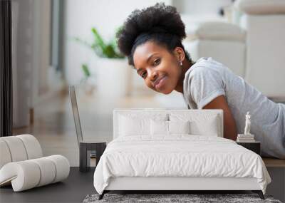 African American woman using a laptop in her living room - Black Wall mural