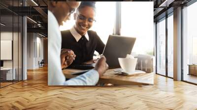 Black  African American coworkers doing digital teamwork arround a coffee cup Wall mural