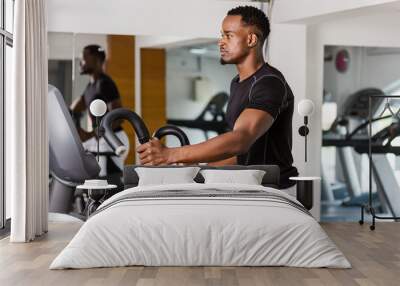 Black African American  young man doing cardio workout at the gym Wall mural