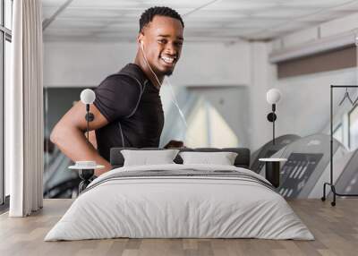 Black African American  young man doing cardio workout at the gym Wall mural