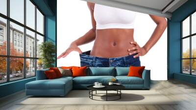 Young african woman in old jeans pant after losing weight Wall mural