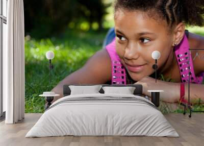 Young black teenage girl  lying on the grass Wall mural