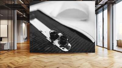 Closeup of a work table of a tattoo artist with plastic ink containers with black ink and napkins (in black and white) Wall mural