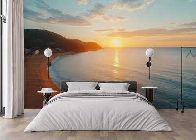 A beautiful aerial view of a beach at sunrise, with the sun shining over the calm ocean and a gentle breeze blowing. Wall mural