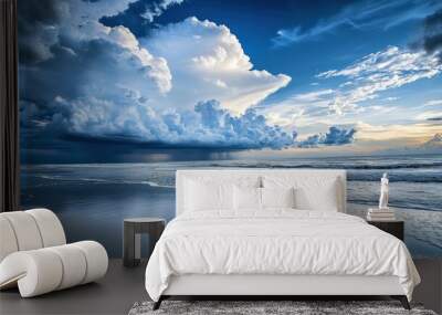 A dramatic, stormy sky over a calm ocean beach with a reflection of the clouds in the water. Wall mural