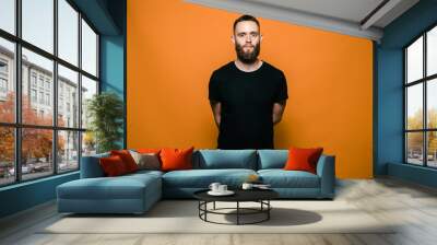 a young man wearing black blank t-shirt. Studio photo. Empty space for text or design Wall mural