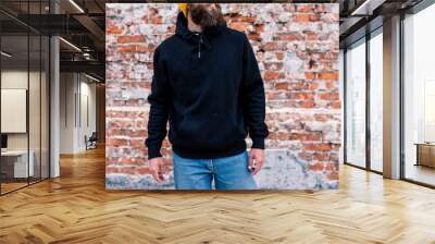 City portrait of handsome guy wearing black blank hoodie and baseball cap with space for your logo or design. Mockup for print Wall mural