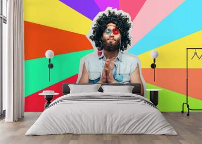 Friendly bearded young male hippie with curly hair in stylish sunglasses isolated on colorful background Wall mural